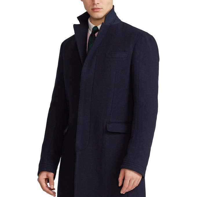 Man wearing navy paddock lined coat under shirt and tie