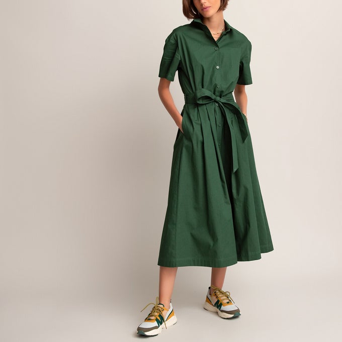 Woman wearing green shirt dress and trainers 