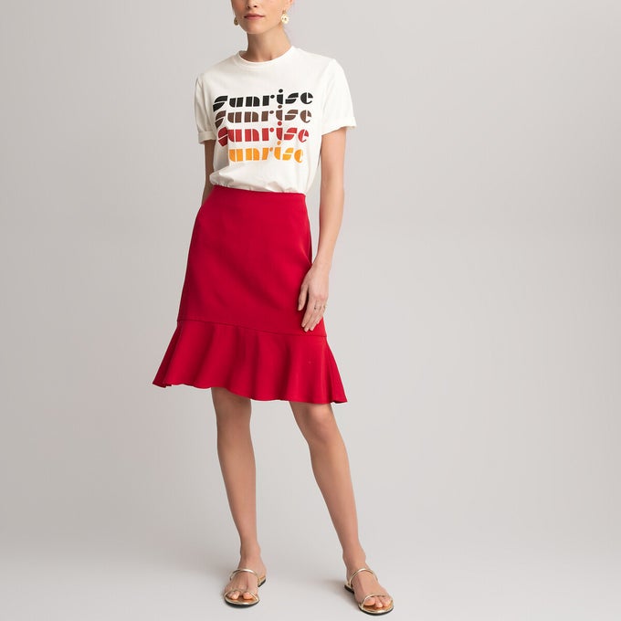 Woman wearing a red ruffle mini skirt with sunrise t-shirt