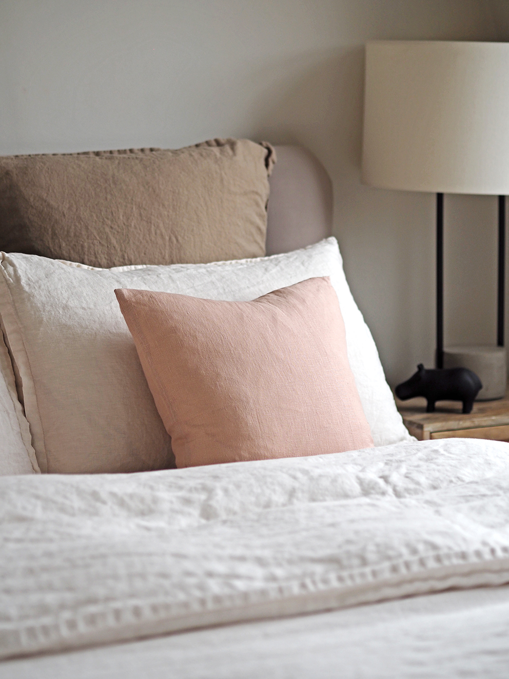 Bed dressed in linen bedding and cushions.jpg
