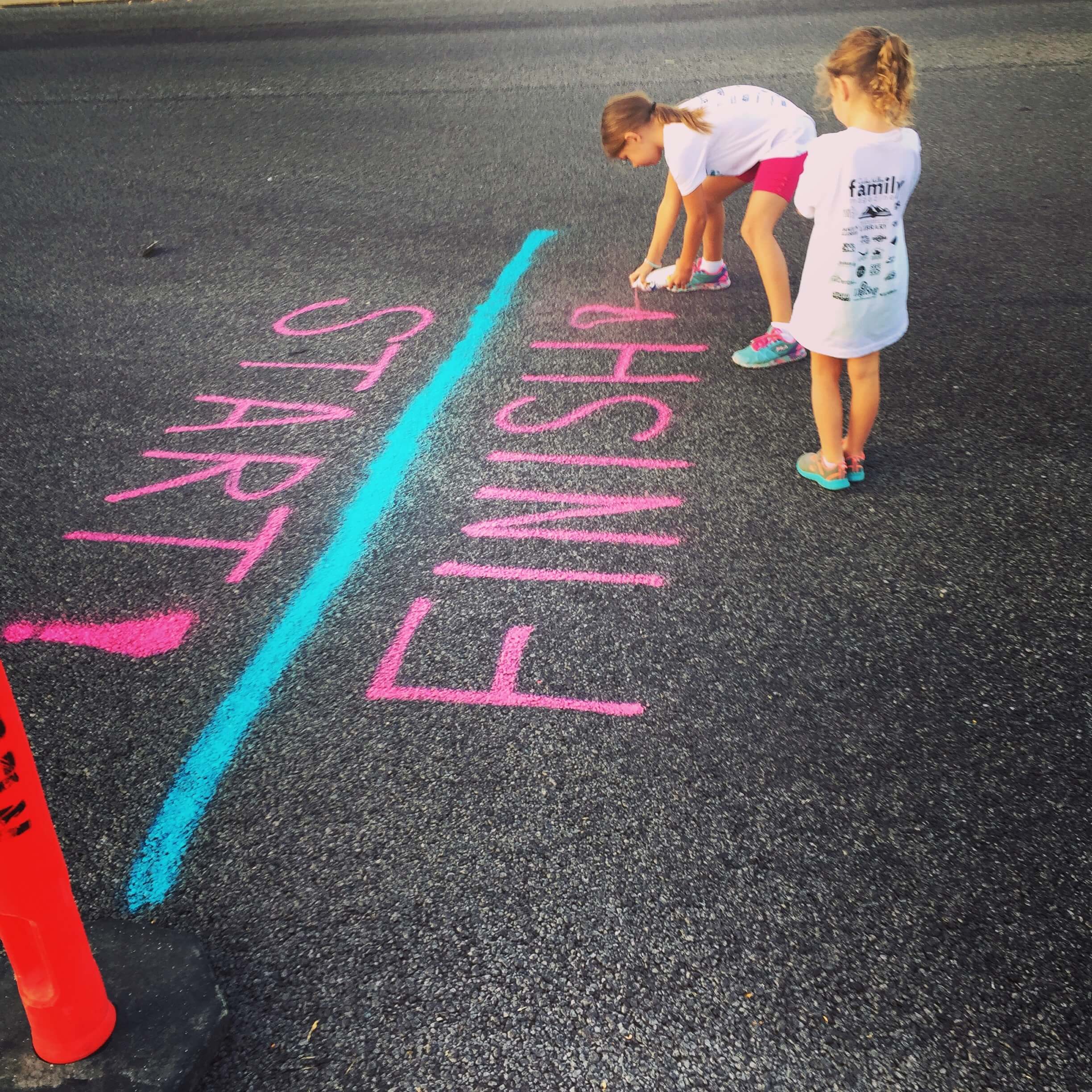 two-children-writing-on-pavement-using-chalk.jpg