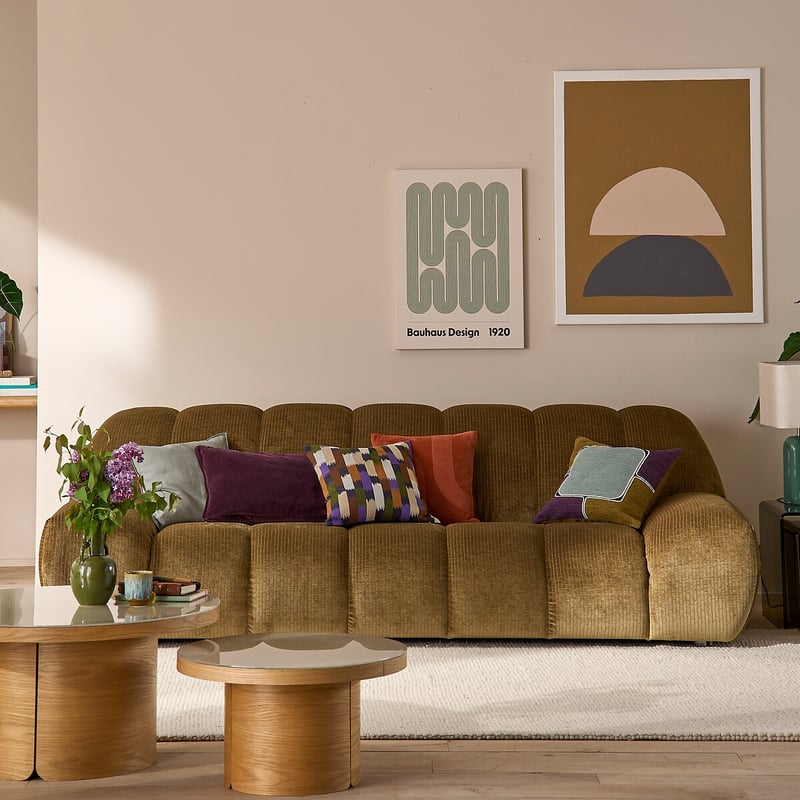 Sofá de tela marrón con cojines decorativos en salón moderno