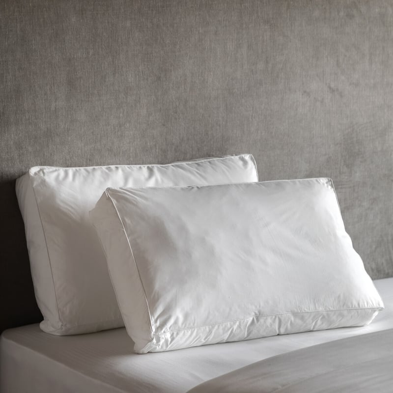 Two white pillows on a bed, suggesting comfort and sleep support
