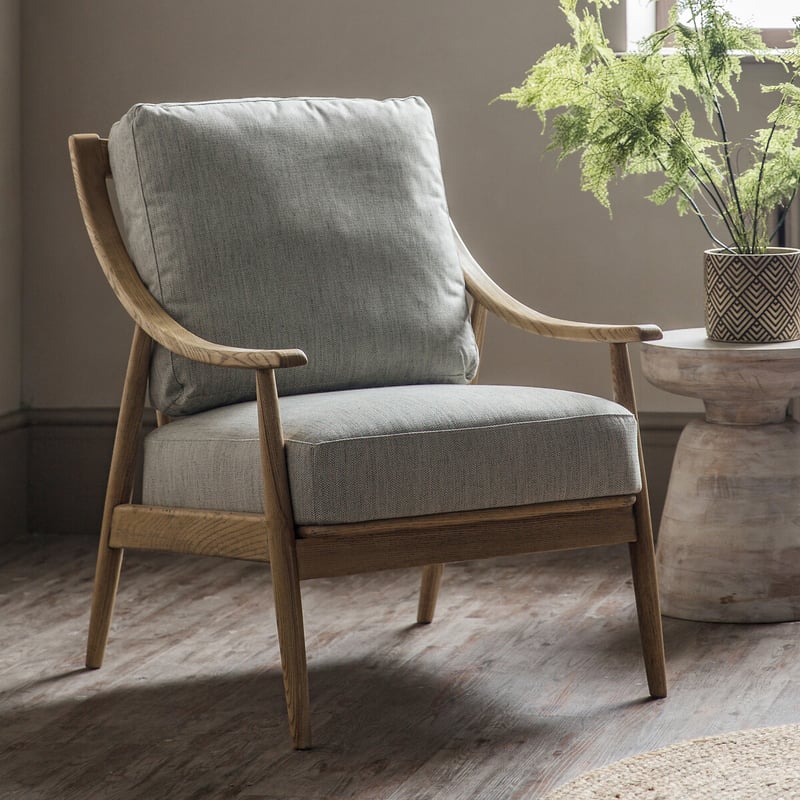 Comfortable reading armchair with wooden frame, upholstered cushions and supportive curved arms
