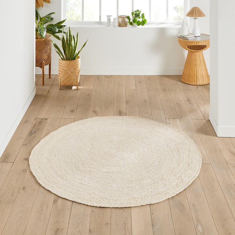 Tappeto rotondo chiaro su pavimento in legno in una casa luminosa