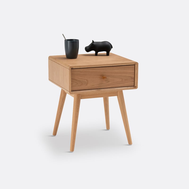 Table de chevet en bois avec tiroir, tasse et objet d&eacute;coratif noir