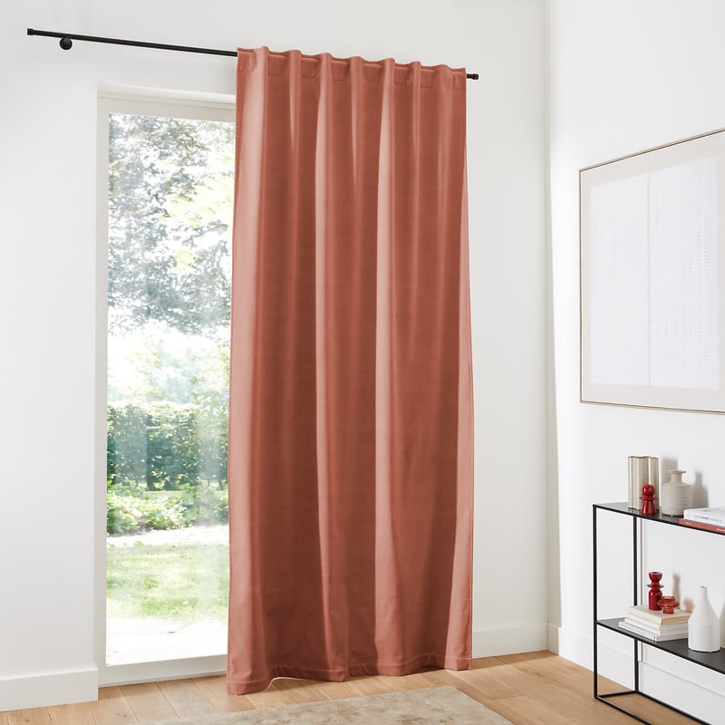 Thermal curtain covering a tall window in a bright home interior