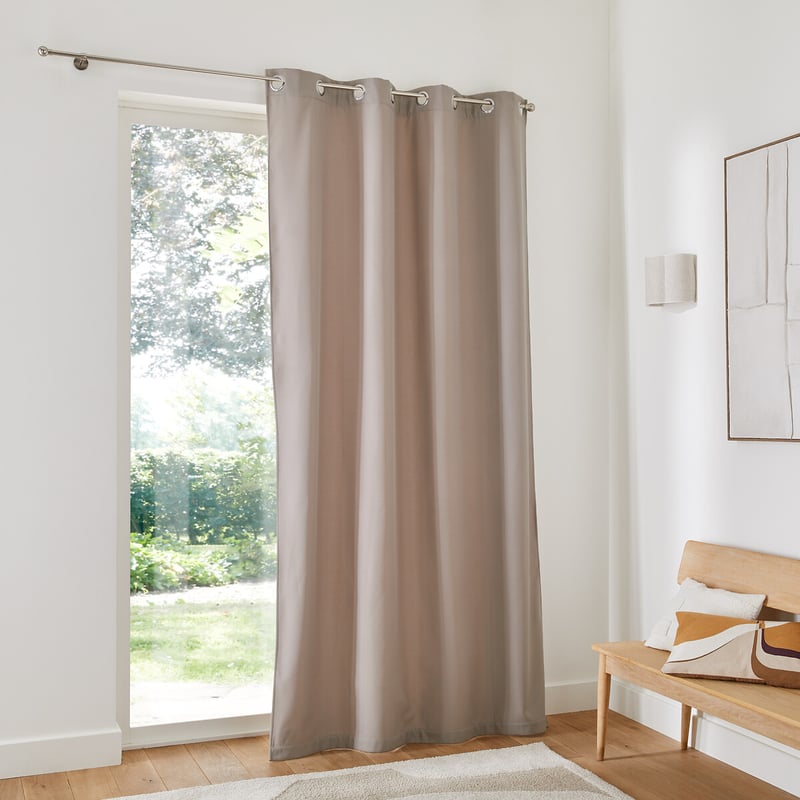 Thermal curtain covering tall window in bright home interior